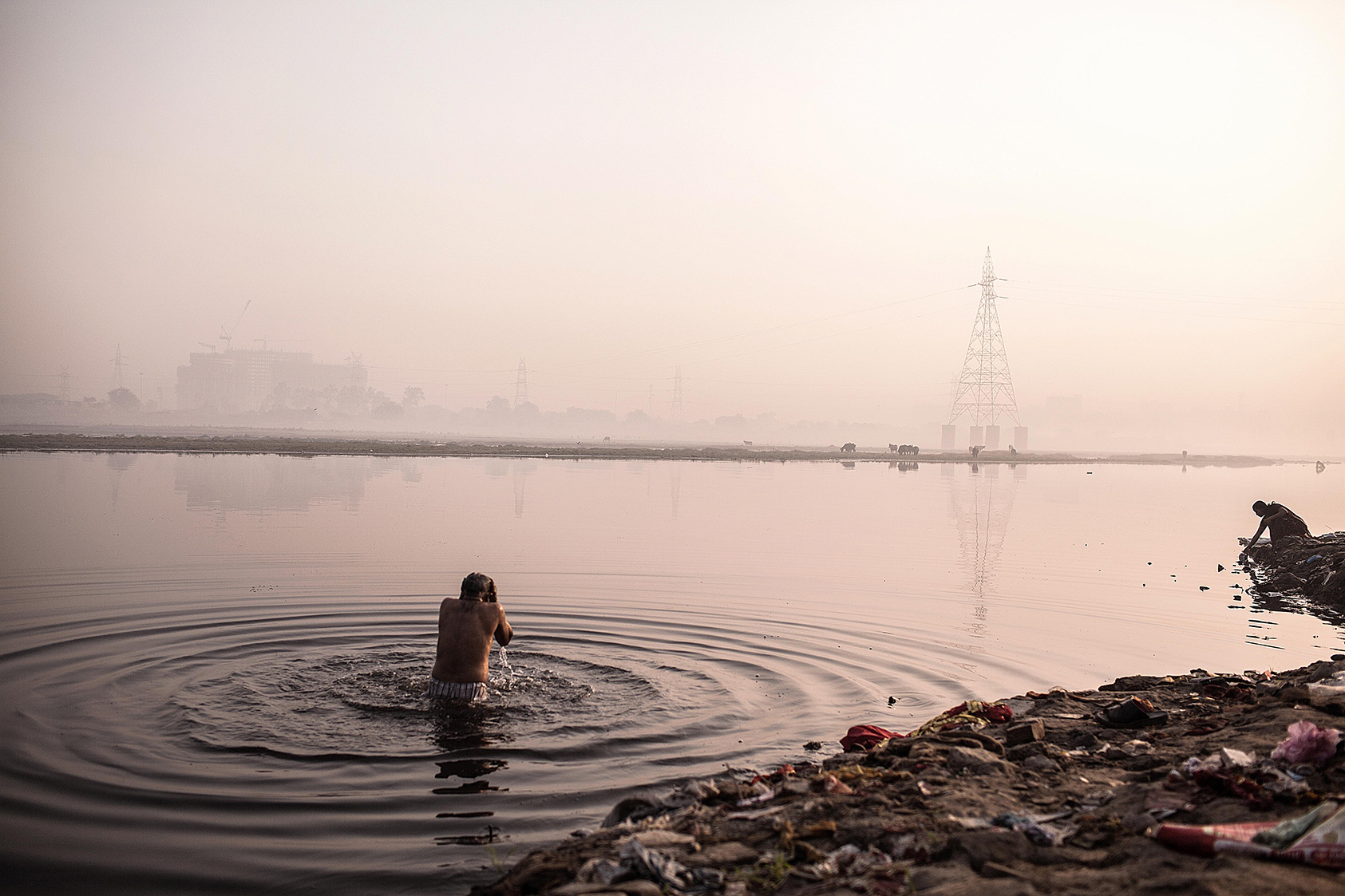 A Hindu devotee offers prayers after a dip in the Yamuna River