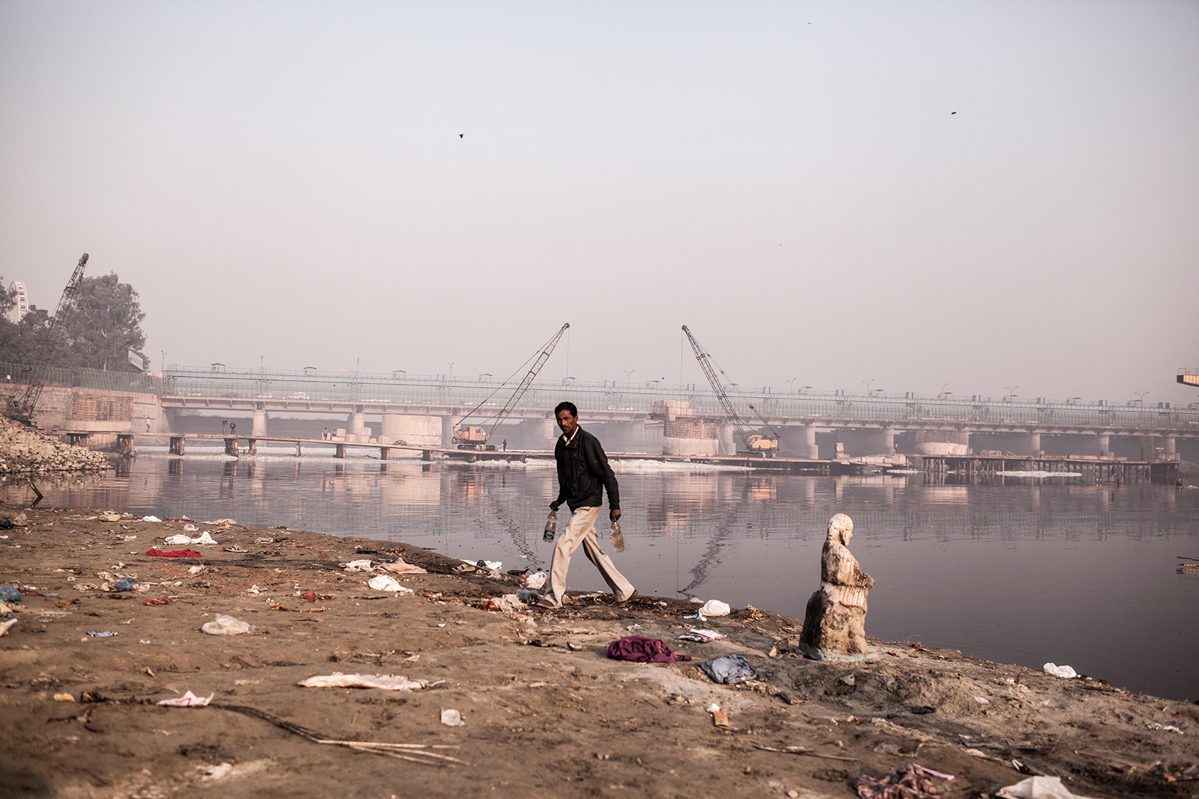 A man filled two bottles of water from Yamuna River, which he believes very sacred