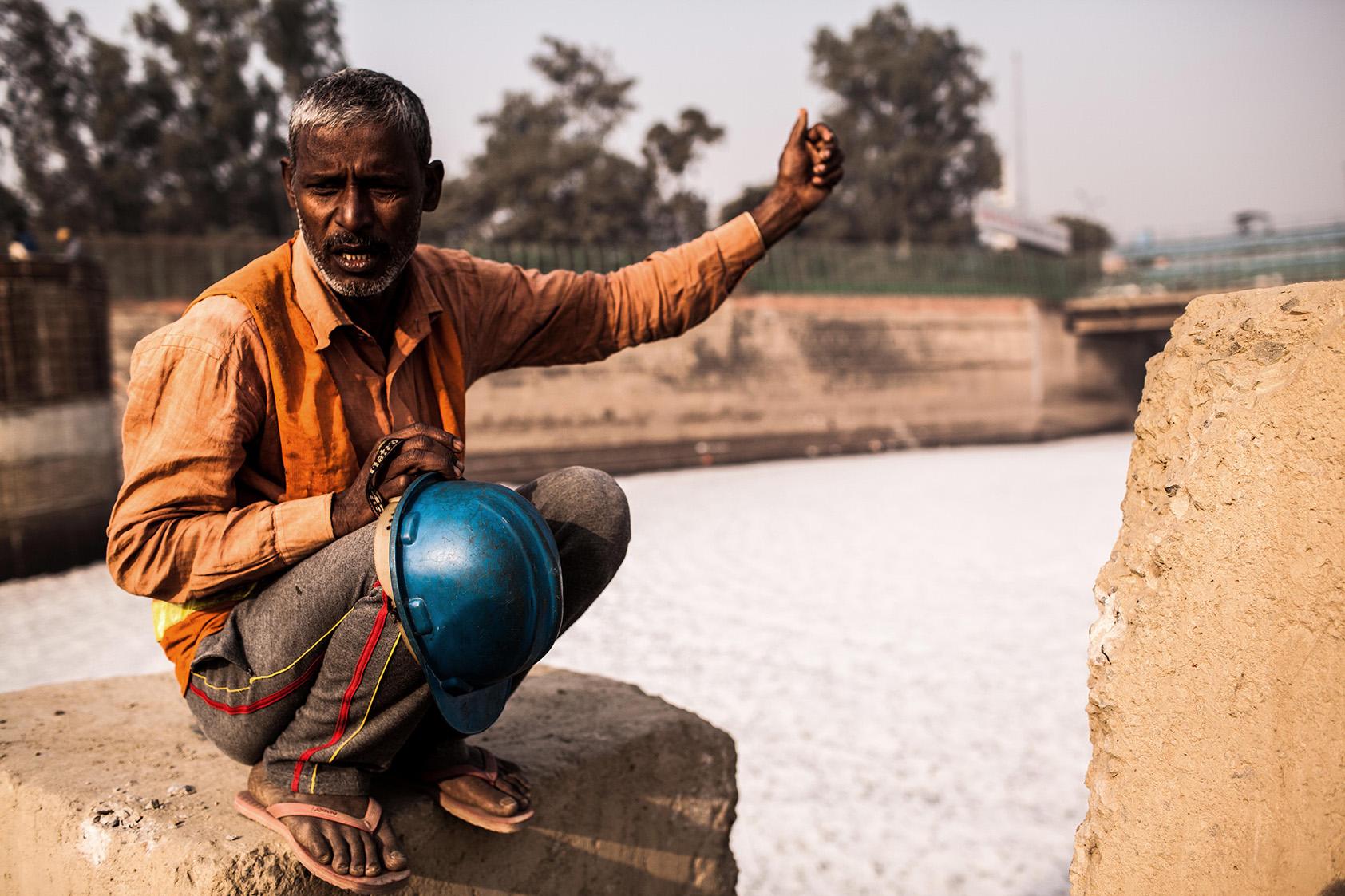 A worker explaining the dirt of Yamuna